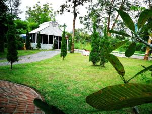 巴真府Saengcha Farm Resort的一座花园,其背后是凉亭,另一座是一座建筑