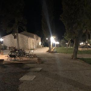 圣吉米纳诺La Tenuta di Castelvecchio的一群桌子和长椅在公园里过夜