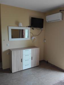莫奈姆瓦夏卡萨莱别墅旅馆的客房设有带镜子的橱柜和电视。