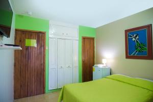 瓜亚基尔瓜亚基尔北星旅馆的一间卧室设有绿色的墙壁、一张床和一扇门