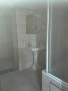 雅莱LA DILIGENCE的白色的浴室设有水槽和淋浴。