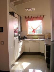 Usedom Town哈弗边纱架庭院公寓的厨房配有白色橱柜和窗户。
