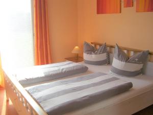 Usedom Town哈弗边纱架庭院公寓的一间卧室配有两张带枕头的床。