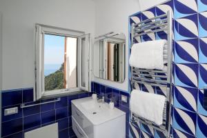 斯卡拉Admiring Amalfi的蓝色和白色的浴室设有水槽和2扇窗户