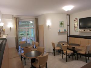 策拉-梅利斯斯登格鲁德酒店的一间带桌椅和电视的用餐室