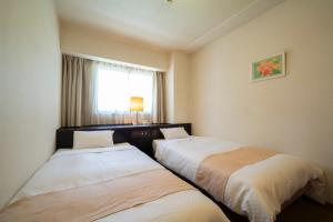名古屋Hotel S-plus Nagoya Sakae的配有窗户的酒店客房内的两张床