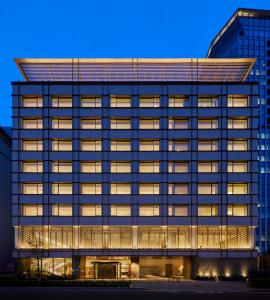 东京THE KITANO HOTEL TOKYO的夜间带照明窗户的办公楼