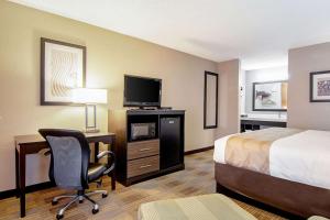 维拉里卡Quality Inn的酒店客房配有一张床、一张桌子和一把椅子。