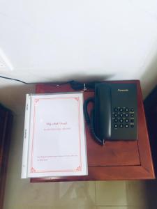 Sa ÐécHotel Mỹ Anh的电话和桌子上的书籍