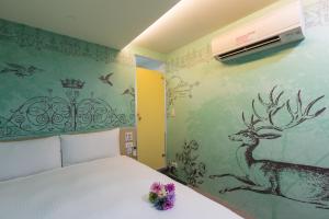 台北清翼居采风馆的卧室配有一张壁挂着鹿的床铺。