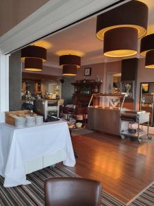 滨海韦斯顿约克酒店的餐厅配有白色的桌子、椅子和灯