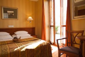 格丁尼亚薇拉卢比奇酒店的卧室配有床、椅子和窗户。