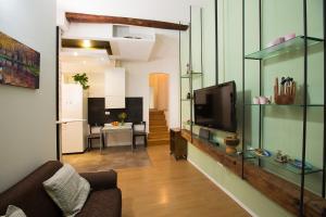 博洛尼亚Guasto Apartment的一间客厅,在玻璃架上配有电视