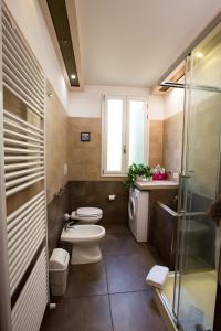 博洛尼亚Guasto Apartment的浴室设有2个卫生间和玻璃淋浴间。