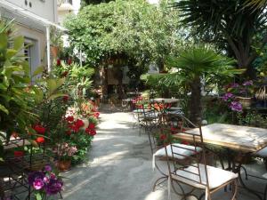 尼斯维克托瑞娜别墅家庭酒店的花园配有桌椅和鲜花
