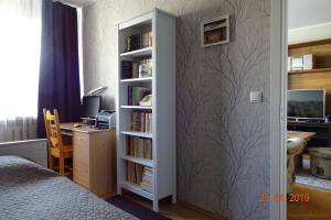 派尔努普伦策尔麦公寓的一间卧室配有书架和书桌