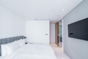 首尔Patio 7的一间卧室配有一张床和一台平面电视