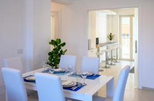 索伦托Angiolina Suite的白色的用餐室配有白色的桌椅