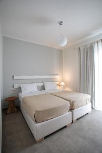 纳克索乔拉Sweet Home Naxos的白色的卧室设有一张大床和一个窗户