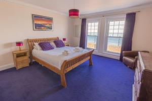 托特兰Promenade Apartment with own Beach Hut的一间卧室配有一张床、一张沙发和窗户。