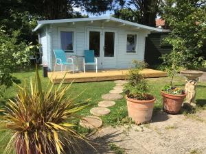 惠茨特布尔Hillview Bed and Breakfast的蓝色的小房子,配有两把椅子和庭院