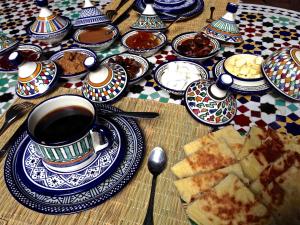 非斯托约尔利亚德比尔兹摩洛哥传统庭院住宅的餐桌,盘子,咖啡
