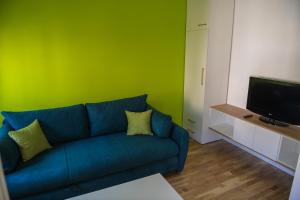 DedinjePuzzle Apartment的客厅设有蓝色的沙发和绿色的墙壁