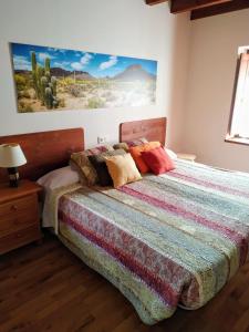 阿里翁达斯El interior de Gaia的一间卧室配有一张带五颜六色被子的床