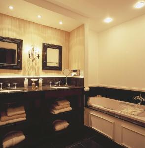 布鲁日玉龙住宿加早餐酒店的一间带浴缸和大镜子的浴室