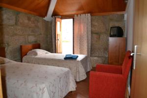 辛方伊什卡萨达昆尼塔达卡拉达酒店的客房设有两张床、一把椅子和电视。
