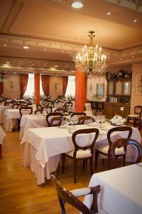 仕格莱Palacio Azcárate Hotel的餐厅配有白色的桌椅和吊灯