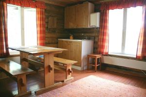 LemmenjokiPaltto Elämysretket的厨房配有木桌、桌子和窗户。
