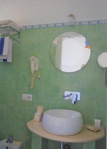 卡普里Hotel Guarracino的绿色瓷砖浴室设有水槽和镜子