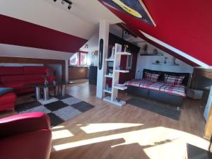 施特拉尔松德Apartments am Sund的一间客厅,配有红色的天花板和红色的沙发