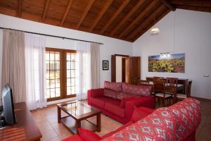 拉哈雷斯Villas & Apartamentos Tao Mazo的客厅配有红色的沙发和桌子