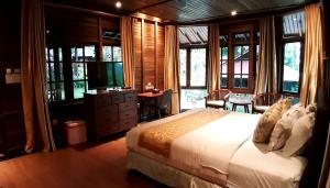 Tomohon高地自然之旅度假酒店 的一间卧室设有一张床、一台电视和窗户。