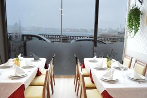 拉科鲁尼亚克瑞丝绦2号酒店的一间设有白色桌椅的餐厅,享有美景
