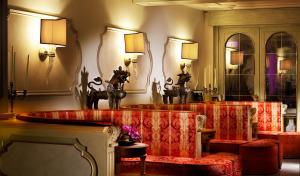加尔多内-里维耶拉Park Hotel Ville Montefiori的客厅配有红色椅子和镜子