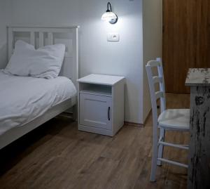 莫托文Casa Rossa Motovun的卧室配有1张床、1张桌子和1把椅子