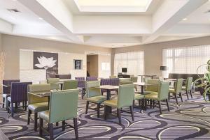 安大略La Quinta Inn & Suites by Wyndham Ontario Airport的大型等候室配有桌椅