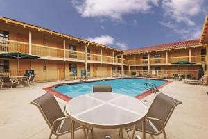 米德兰米德兰拉昆塔酒店的一个带桌椅的庭院和一个游泳池