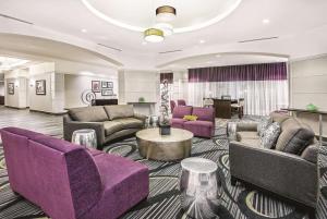 圣安东尼奥La Quinta Inn & Suites by Wyndham San Antonio Riverwalk的酒店大堂设有紫色家具和桌子