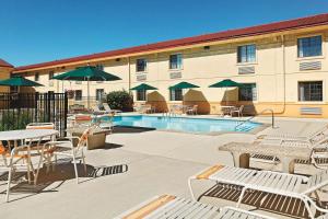 尚佩恩查姆平拉库恩塔旅馆的酒店庭院设有桌椅和游泳池。