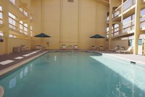 阿尔伯克基阿尔伯克基机场拉金塔酒店的一座带桌子和遮阳伞的大型游泳池