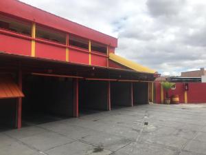 贝洛奥里藏特MOTEL RED LOVE的一座红色和黄色的建筑,设有停车场