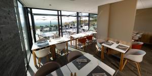 蒙特-圣-奥博特弗洛雷亚尔美景酒店的餐厅设有桌椅和大窗户。