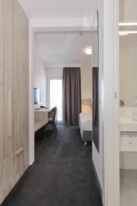 扎达尔美地特兰酒店的酒店客房带一张床铺、一张书桌和一间卧室