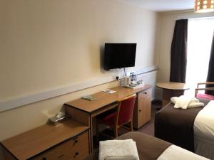 BraeThe Brae Hotel的酒店客房配有一张书桌、一台电视和一张床