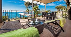 罗维尼Apartments Figarola的一个带桌椅的庭院和大海