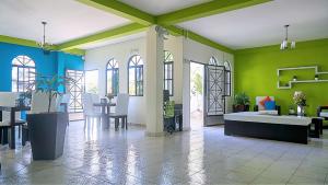 圣萨尔瓦多天使别墅酒店的客厅拥有绿色和白色的墙壁,配有桌子